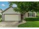 Inviting home featuring a well-manicured lawn, two-car garage, and a warm, welcoming facade at 6937 Thousand Oaks Dr, Indianapolis, IN 46214