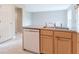 Galley kitchen with stainless steel sink, gray countertops, and white dishwasher at 6937 Thousand Oaks Dr, Indianapolis, IN 46214