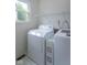 Bright laundry room featuring a white washer and dryer, with a window at 6937 Thousand Oaks Dr, Indianapolis, IN 46214