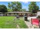 Backyard featuring a well-maintained lawn, deck with outdoor seating, and mature trees at 7113 Chandler Dr, Indianapolis, IN 46217