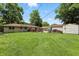 Large backyard with well-maintained lawn, and a wooden deck at the rear of the house at 7113 Chandler Dr, Indianapolis, IN 46217
