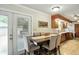 Dining area highlighting a wood table with seating, complemented by natural light and a view to the kitchen at 7113 Chandler Dr, Indianapolis, IN 46217