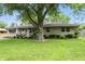 Inviting single-story home featuring a lush front lawn with mature trees providing ample shade at 7113 Chandler Dr, Indianapolis, IN 46217