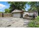 View of the detached garage with wooden deck, basketball hoop and ample parking at 7113 Chandler Dr, Indianapolis, IN 46217