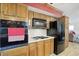 Kitchen with built-in oven and microwave, alongside a refrigerator, and wood cabinets at 7113 Chandler Dr, Indianapolis, IN 46217