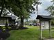 A shot of the common area with mature tree, lawn, American flag and playground at 7220 Village Pkwy Dr # 3, Indianapolis, IN 46254