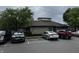 A view of the building's exterior with a cloudy sky, trees, and several parked cars at 7220 Village Pkwy Dr # 3, Indianapolis, IN 46254