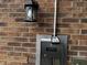Close up of key box and entry system mounted to brick wall with light fixture above at 7220 Village Pkwy Dr # 3, Indianapolis, IN 46254