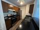 Stainless steel oven and refrigerator in kitchen with wood cabinets and black countertops at 7220 Village Pkwy Dr # 3, Indianapolis, IN 46254