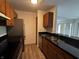 Well-lit kitchen with wooden cabinets, stainless steel appliances, and black countertops at 7220 Village Pkwy Dr # 3, Indianapolis, IN 46254