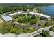 An aerial view of the NewPort Bay Condominiums featuring lush landscaping, a serene pond, and easy access to a beautiful lake at 7601 Newport Bay Dr # 115, Indianapolis, IN 46240