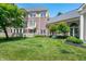 Beautifully landscaped backyard features a lush lawn, mature trees, and architectural details at 7601 Newport Bay Dr # 115, Indianapolis, IN 46240