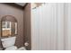 Cozy bathroom with a decorative mirror, toilet, and shower with white curtain at 7601 Newport Bay Dr # 115, Indianapolis, IN 46240