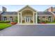 Attractive building exterior with brick facade, white columns, arched windows, and colorful flower arrangements at 7601 Newport Bay Dr # 115, Indianapolis, IN 46240