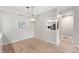 Open dining room featuring wood floors, a modern light fixture, and a pass-through to the kitchen at 7601 Newport Bay Dr # 115, Indianapolis, IN 46240