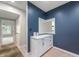 Hallway with a decorative rug, blue accent wall, and a white cabinet with drawers and cabinets at 7601 Newport Bay Dr # 115, Indianapolis, IN 46240