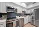 Updated kitchen with stainless steel appliances, white cabinets, and modern countertops at 7601 Newport Bay Dr # 115, Indianapolis, IN 46240