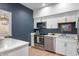 Modern kitchen featuring stainless steel appliances, white cabinets, and a blue accent wall at 7601 Newport Bay Dr # 115, Indianapolis, IN 46240