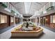 Elegant lobby at NewPort Bay Condominiums featuring a central water feature and skylights providing a welcoming common area at 7601 Newport Bay Dr # 115, Indianapolis, IN 46240