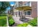 Charming outdoor patio with table and chairs, surrounded by lush landscaping and a white picket fence at 7601 Newport Bay Dr # 115, Indianapolis, IN 46240