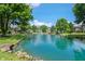 Scenic view of a community pond and fountain surrounded by trees and residences at 7601 Newport Bay Dr # 115, Indianapolis, IN 46240