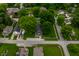 A high-angle shot shows the house, big trees, and the surrounding neighborhood at 7727 Huff St, Indianapolis, IN 46259