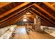 Spacious attic featuring exposed wood beams, brick chimney and ample insulation at 7727 Huff St, Indianapolis, IN 46259