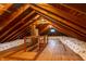 Spacious attic featuring exposed wood beams, brick chimney and ample insulation at 7727 Huff St, Indianapolis, IN 46259