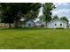 Large backyard featuring ample lawn space, trees, and neighboring homes at 7727 Huff St, Indianapolis, IN 46259
