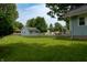 The backyard features a green lawn and detached outbuilding, ideal for relaxation and outdoor activities at 7727 Huff St, Indianapolis, IN 46259