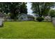 A lush, green backyard features an outbuilding, a well-manicured lawn, and mature trees at 7727 Huff St, Indianapolis, IN 46259