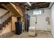 Basement with water filtration system, stairs to upper level, and concrete floor at 7727 Huff St, Indianapolis, IN 46259