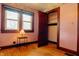 A bedroom with salmon colored walls, vintage wallpaper trim, and closet with open wood door at 7727 Huff St, Indianapolis, IN 46259