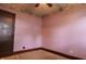 Cozy bedroom features pink walls, vintage wallpaper trim, and hardwood door at 7727 Huff St, Indianapolis, IN 46259