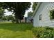 Side view of the house showing the siding, window, and large backyard at 7727 Huff St, Indianapolis, IN 46259