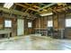 A spacious garage featuring bright lighting, a work bench, and visible beams at 7727 Huff St, Indianapolis, IN 46259