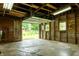 The interior of a garage features exposed beams and an open door to the backyard at 7727 Huff St, Indianapolis, IN 46259