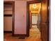 View from a doorway looking down the hallway with salmon colored walls and wood trim at 7727 Huff St, Indianapolis, IN 46259