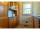 The kitchen features a combination of glass-front and solid wood cabinets with updated countertops and appliances at 7727 Huff St, Indianapolis, IN 46259