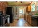 The kitchen shows modern appliances, mosaic backsplash, and a brick accent wall, illuminated by natural light at 7727 Huff St, Indianapolis, IN 46259