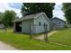 A detached outbuilding with a garage door and entry gate sits on a well-kept lawn at 7727 Huff St, Indianapolis, IN 46259