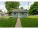 A light-blue outbuilding, with a matching door and small windows, is surrounded by well-maintained grass and fencing at 7727 Huff St, Indianapolis, IN 46259