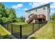 Well-maintained backyard with a black fence, grassy area, and a deck overlooking the yard at 773 Bracknell Dr, Avon, IN 46123