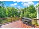 Red stained deck with a black grill on a sunny day, overlooking a treed backyard at 773 Bracknell Dr, Avon, IN 46123