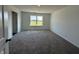 Neutral bedroom with a large window showing a scenic view and soft carpet floors at 7909 Magnolia St, New Palestine, IN 46163