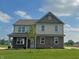 Inviting two-story home with brick accents, a covered porch, and well-maintained lawn on a beautiful day at 7909 Magnolia St, New Palestine, IN 46163