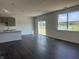 Spacious living room area with sliding glass door, large windows, and hardwood floors overlooking the lake at 7909 Magnolia St, New Palestine, IN 46163