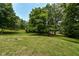 Rolling backyard with mature trees at 8004 Lafayette Rd, Indianapolis, IN 46278