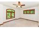 Carpeted bedroom with ceiling fan and windows with wood trim at 8004 Lafayette Rd, Indianapolis, IN 46278