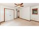Carpeted bedroom with ceiling fan, closet, and window with wood trim at 8004 Lafayette Rd, Indianapolis, IN 46278
